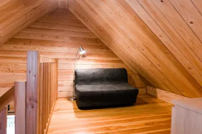a black chair sitting in the middle of a attic at Huttopia Sutton in Sutton