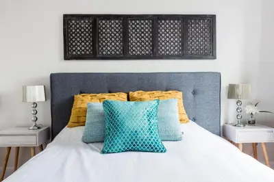 a bedroom with a bed with blue and yellow pillows at MTLVacationrentals-The MTLVR Kisses in Montréal