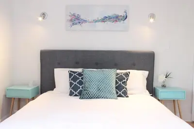 a bedroom with a bed with two blue tables at MTLVacationrentals-The MTLVR Kisses in Montréal