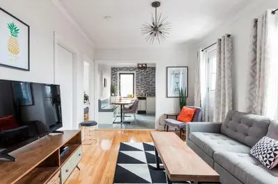 a living room with a couch and a tv at MTLVacationrentals-The MTLVR Kisses in Montréal