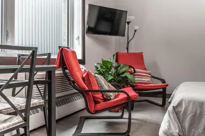 a room with two chairs and a table and a tv at Cjour Apartments in Montréal