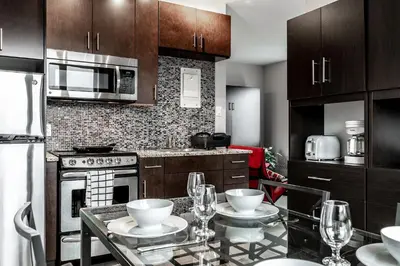 a kitchen with a table with wine glasses on it at Cjour Apartments in Montréal