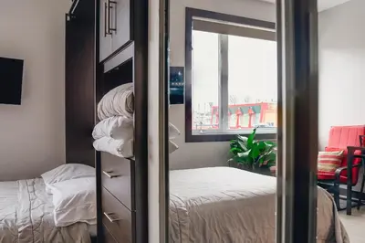 a bedroom with a bed and a window and a mirror at Cjour Apartments in Montréal