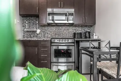 a kitchen with a stove and a microwave at Cjour Apartments in Montréal