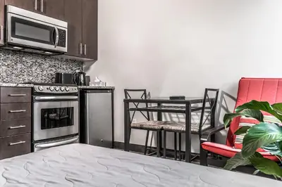 a kitchen with a table and chairs and a microwave at Cjour Apartments in Montréal