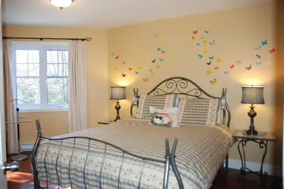 a bedroom with a bed with butterflies on the wall at Lecomte De La Fontaine in North Hatley