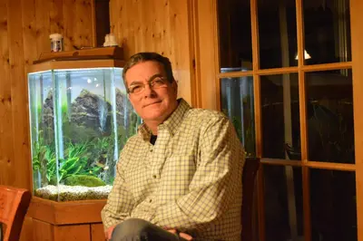 a man sitting in front of a fish tank at Lecomte De La Fontaine in North Hatley