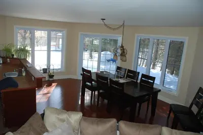 a living room with a dining room table and chairs at Lecomte De La Fontaine in North Hatley