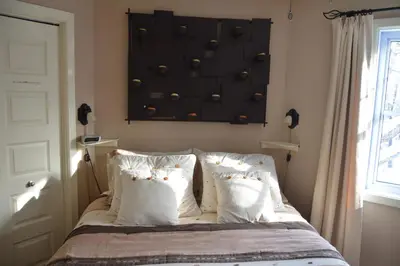 a bed with white pillows and a baseball wall at Lecomte De La Fontaine in North Hatley