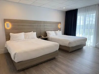 a hotel room with two beds and a large window at La Porte de la Mauricie in Louiseville