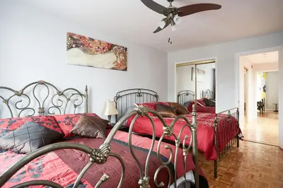 a bedroom with two beds and a ceiling fan at Big Cozy House in Montréal