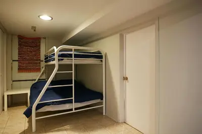 a bunk bed room with two bunk beds and a door at Big Cozy House in Montréal
