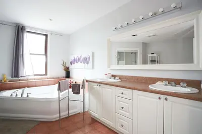 a bathroom with two sinks and a tub and a mirror at Big Cozy House in Montréal