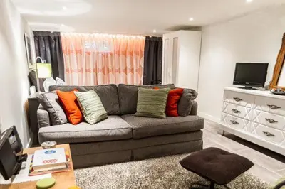 a living room with a gray couch with colorful pillows at L'Adresse Botanique - Studio in Montréal