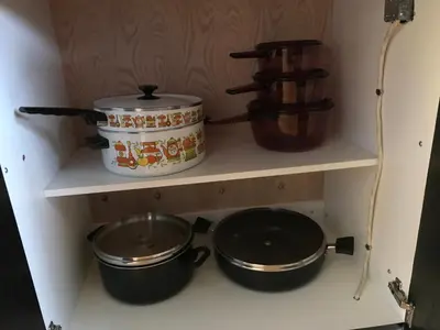 two pots and pans on a shelf in a kitchen at La Maison des Éboulis in Victoriaville