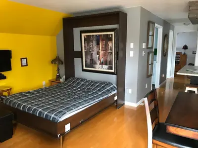 a bedroom with a bed and a yellow wall at La Maison des Éboulis in Victoriaville