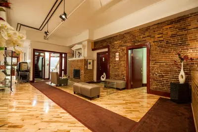 a large living room with a brick wall at Hotel Abri du Voyageur in Montréal