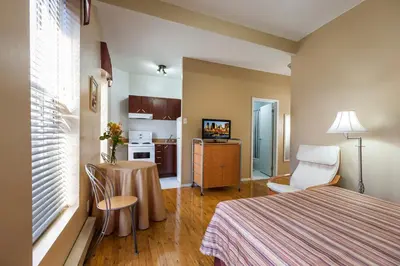 a hotel room with a bed and a table and chair at Hotel Abri du Voyageur in Montréal