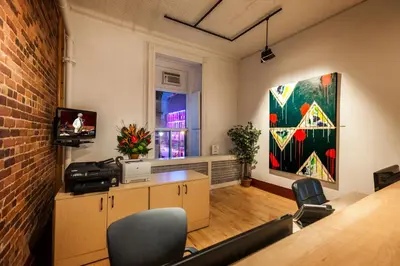 an office with a table and chairs and a painting at Hotel Abri du Voyageur in Montréal