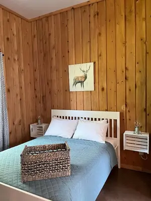 a bedroom with a bed and a picture of a deer on the wall at Chalets du Domaine Yamaska in Bromont