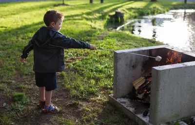 a young boy playing with a fire in a box at Chalets du Domaine Yamaska in Bromont