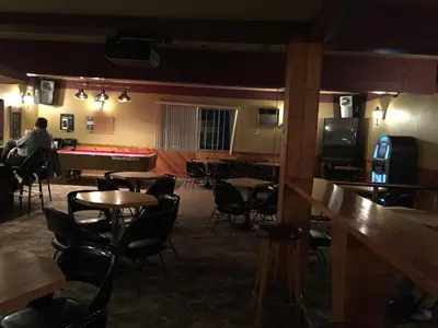 a room with tables and chairs and a bar at Hotel Motel Arnold in Woburn