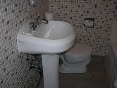 a bathroom with a white sink and a toilet at Hotel Motel Arnold in Woburn