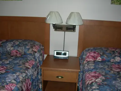 a hotel room with a bed and a table with a clock on it at Hotel Motel Arnold in Woburn