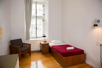 a bedroom with a bed and a chair and a window at The Grey Nuns Residence by Concordia University in Montréal