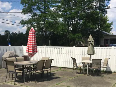 a patio with tables and chairs and an umbrella at Motel le Sabre in Sherbrooke
