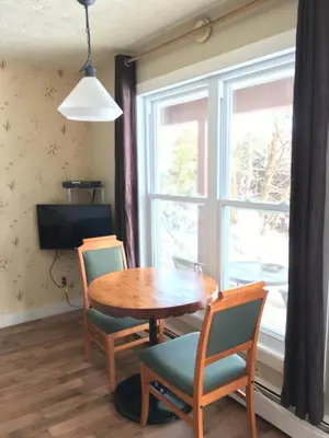 a dining room with a table and chairs and a window at Motel le Sabre in Sherbrooke