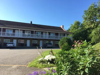 a large building with flowers in front of it at Motel le Sabre in Sherbrooke