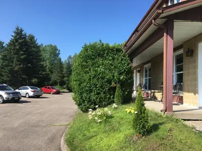 a building with cars parked in a parking lot at Motel le Sabre in Sherbrooke