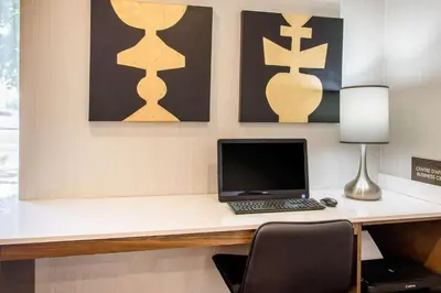 a desk with a laptop and a lamp on it at Comfort Inn Montreal Aeroport in Pointe-Claire