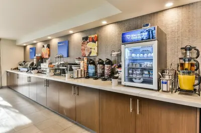 a kitchen with a counter with a refrigerator at Comfort Inn Montreal Aeroport in Pointe-Claire