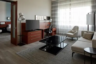 a living room with a couch and a tv at Marriott Montreal Airport In-Terminal Hotel in Dorval