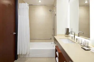 a bathroom with a tub and a shower and a sink at Marriott Montreal Airport In-Terminal Hotel in Dorval