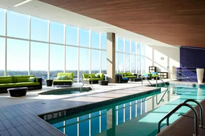 a swimming pool in a building with a view of the city at Marriott Montreal Airport In-Terminal Hotel in Dorval
