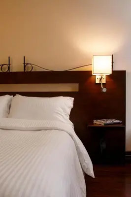 a bedroom with a large white bed and a lamp at Auberge du Vieux Port by Gray Collection in Montréal