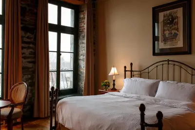 a bedroom with a bed and a large window at Auberge du Vieux Port by Gray Collection in Montréal