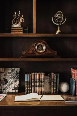 a shelf with books and a clock and a book at Auberge du Vieux Port by Gray Collection in Montréal