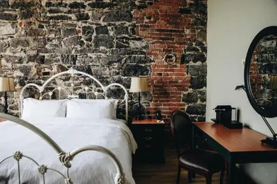 a bedroom with a bed and a brick wall at Auberge du Vieux Port by Gray Collection in Montréal