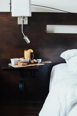 a tray of food on a table next to a bed at Auberge du Vieux Port by Gray Collection in Montréal