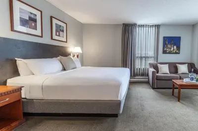a hotel room with a large bed and a couch at Hôtel Saint-Laurent Montréal in Montréal