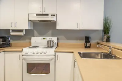 a kitchen with a white stove and a sink at Hôtel Saint-Laurent Montréal in Montréal