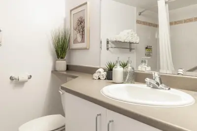 a bathroom with a sink and a toilet and a mirror at Hôtel Saint-Laurent Montréal in Montréal