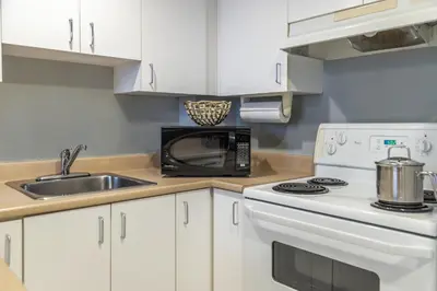 a kitchen with a stove and a microwave at Hôtel Saint-Laurent Montréal in Montréal