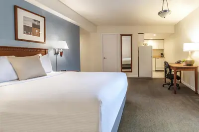 a bedroom with a large white bed and a desk at Hôtel Saint-Laurent Montréal in Montréal