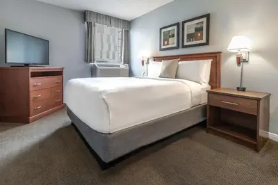 a bedroom with a large bed and a television at Hôtel Saint-Laurent Montréal in Montréal