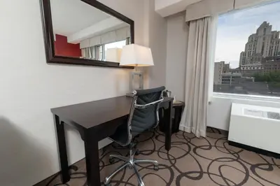 a room with a desk and a chair and a window at Holiday Inn Montreal Centre Ville Downtown by IHG in Montréal